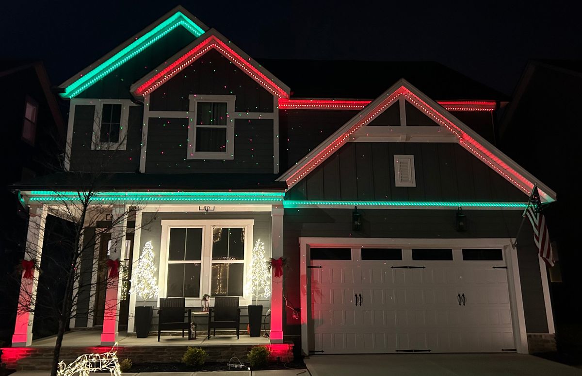 Two-story home with red and green permanent roofline lighting